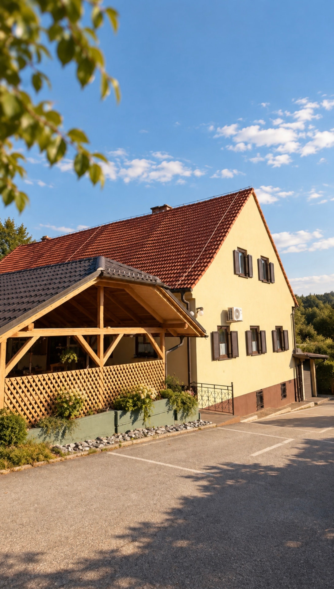 Zunanjost Gostišča Sobočan s pokrito teraso in cvetličnimi gredami